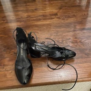 Black patent leather laced block heel pumps.